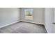 Carpeted bedroom with a window bringing in natural light, light grey walls, and white trim at 563 Viceroy Ct, Kissimmee, FL 34758