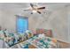 Bright bedroom with twin beds, dinosaur-themed bedding, cartoon wall decals, and natural light at 620 Old Bridge Cir, Davenport, FL 33897