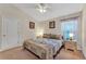 Comfortable bedroom with a cozy bed, window with blinds and curtains, nightstand, and neutral colored walls at 620 Old Bridge Cir, Davenport, FL 33897
