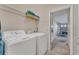 Functional laundry room with washer, dryer, overhead shelving, and convenient access to the garage at 620 Old Bridge Cir, Davenport, FL 33897