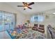 Bright playroom with colorful rug, comfortable seating, and sliding door to the backyard at 620 Old Bridge Cir, Davenport, FL 33897