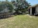 Spacious backyard featuring mature trees, a trampoline, and patio at 6480 Fall St, St Cloud, FL 34771