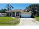 Charming one-story home with a manicured lawn and an attached two-car garage at 6480 Fall St, St Cloud, FL 34771