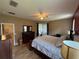 Main bedroom showcasing a dresser, ceiling fan, and hardwood flooring at 6480 Fall St, St Cloud, FL 34771