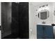 Modern bathroom featuring dark marble tiling in the shower, a round mirror, and modern fixtures at 650 Main St, Altamonte Springs, FL 32701