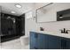 Modern bathroom featuring a double vanity with blue cabinets and a sleek, glass-enclosed shower at 650 Main St, Altamonte Springs, FL 32701