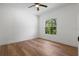 This bedroom features hardwood floors, neutral paint, a ceiling fan and a window providing lots of natural light at 650 Main St, Altamonte Springs, FL 32701