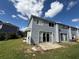 Backyard view of home shows sliding glass doors and lawn at 709 Orchid Dr, Davenport, FL 33897