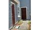 Exterior shot of the unit entrance, with wood-style doors and neutral-colored siding at 709 Orchid Dr, Davenport, FL 33897