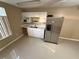 Galley kitchen features stainless steel refrigerator, white cabinets, and bright white countertops at 709 Orchid Dr, Davenport, FL 33897