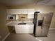 Kitchen showcasing white cabinetry, stainless steel refrigerator, and a microwave at 709 Orchid Dr, Davenport, FL 33897