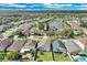 Aerial view of neighborhood homes, some with pools, with a lake in the distance at 721 Hardwood Cir, Orlando, FL 32828