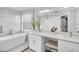 Bright bathroom featuring double sinks with marble countertops, a soaking tub and a separate glass-enclosed shower at 721 Hardwood Cir, Orlando, FL 32828