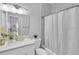 Bright bathroom featuring a single sink vanity with white countertops and a shower behind a curtain at 721 Hardwood Cir, Orlando, FL 32828