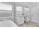 Bright bathroom featuring double sinks with marble countertops, a soaking tub and a separate glass-enclosed shower at 721 Hardwood Cir, Orlando, FL 32828