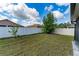 Large backyard is fenced in, featuring green grass and mature tree for shade at 802 Massy Ct, Kissimmee, FL 34759