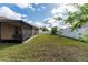 Expansive backyard featuring a screened lanai, green lawn, and a white privacy fence, ideal for outdoor enjoyment at 802 Massy Ct, Kissimmee, FL 34759
