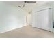 Neutral bedroom with tile floors, bi-fold closet doors, and ceiling fan at 802 Massy Ct, Kissimmee, FL 34759