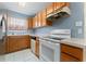 Bright kitchen showcasing white appliances, wooden cabinets, and a window above the sink at 802 Massy Ct, Kissimmee, FL 34759
