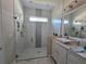 Modern bathroom with a glass-enclosed shower, white vanity, and stylish fixtures at 8270 Topsail Pl, Winter Garden, FL 34787