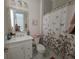 Bright bathroom with white vanity, decorative mirror, and floral shower curtain at 8270 Topsail Pl, Winter Garden, FL 34787