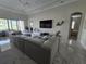 Spacious living room with an oversized sectional sofa, media center, and view of the backyard at 8270 Topsail Pl, Winter Garden, FL 34787