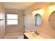 Updated bathroom features a shower/tub combo, round mirror and vanity at 894 Superior St, Deltona, FL 32725