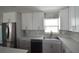 Bright kitchen featuring stainless steel refrigerator, white cabinets, and marble backsplash at 894 Superior St, Deltona, FL 32725