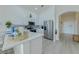 Bright, white kitchen with stainless steel appliances and breakfast bar with white countertop at 926 Balmoral Dr, Davenport, FL 33896