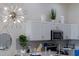 White kitchen cabinets and decor feature a statement chandelier and stainless steel appliances at 926 Balmoral Dr, Davenport, FL 33896