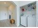 Convenient laundry area with modern appliances, storage shelves, and easy access to hallway at 926 Balmoral Dr, Davenport, FL 33896