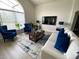 Elegant living room featuring bright, natural light, stylish furniture, and a modern entertainment center at 926 Balmoral Dr, Davenport, FL 33896