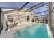 Sparkling pool in a screened enclosure, surrounded by loungers, offers a private oasis for relaxation at 926 Balmoral Dr, Davenport, FL 33896