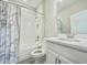 This bathroom boasts a shower over tub with white tile and a gray shower curtain at 1001 Umbria Dr, Poinciana, FL 34759