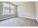 This bedroom features gray wood-look tile flooring, a large window, and neutral paint at 1001 Umbria Dr, Poinciana, FL 34759