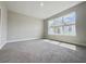 This bedroom boasts neutral carpet, paint, and a large window at 1001 Umbria Dr, Poinciana, FL 34759