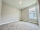 This bedroom is a blank slate with neutral carpet, paint, and a large window at 1001 Umbria Dr, Poinciana, FL 34759