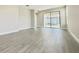 This living room has gray wood-look tile, neutral paint, and access to the porch at 1001 Umbria Dr, Poinciana, FL 34759