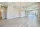 Expansive living room with modern flooring, elegant chandelier, and access to outdoor space through sliding glass doors at 1001 Umbria Dr, Poinciana, FL 34759