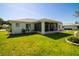 This backyard has a lush lawn, a screen enclosed porch, and low wall landscaping at 10237 Sw 63Rd Ave, Ocala, FL 34476