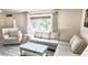 Bright living room with neutral tones, big window, and comfortable neutral tone sofa and armchair at 10237 Sw 63Rd Ave, Ocala, FL 34476