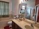 Bathroom featuring double sinks, a large mirror and a separate tub and shower at 1107 Dartford Dr, Kissimmee, FL 34758