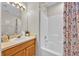 Bathroom featuring bright lights and tiled shower with white vanity and decor at 1113 Casterton Cir, Davenport, FL 33897