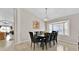 Elegant dining room with a bay window, modern light fixture, a wooden table set for eight, and hardwood floors at 1113 Casterton Cir, Davenport, FL 33897