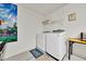 Functional laundry area features modern washer and dryer, storage shelves, and clean white walls at 1113 Casterton Cir, Davenport, FL 33897