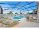 Relaxing screened-in pool area with ample seating and sun loungers at 1113 Casterton Cir, Davenport, FL 33897
