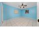 Comfortable bedroom featuring light blue walls, tile flooring, and a ceiling fan for a relaxing atmosphere at 1209 Marygon St, Kissimmee, FL 34744