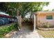 Side yard with gravel, fencing, mature trees and space for plants at 1209 Marygon St, Kissimmee, FL 34744