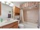 Bathroom vanity with a shower-tub combination featuring neutral tile and wood cabinets at 1258 Donalds Pl, The Villages, FL 32162