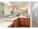 Bathroom features a double sink vanity, decorative mirrors, and a makeup area with a stool at 1258 Donalds Pl, The Villages, FL 32162